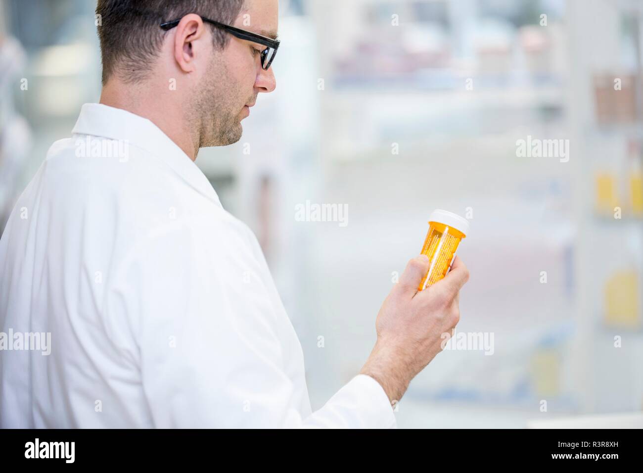 Apotheker lesen Label auf Pille Flasche in der Apotheke. Stockfoto