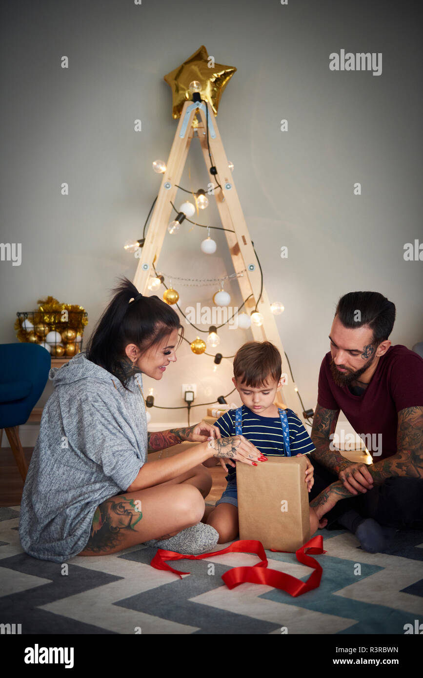 Junge, Öffnung, Weihnachten mit seinen Eltern zu Hause vorhanden Stockfoto