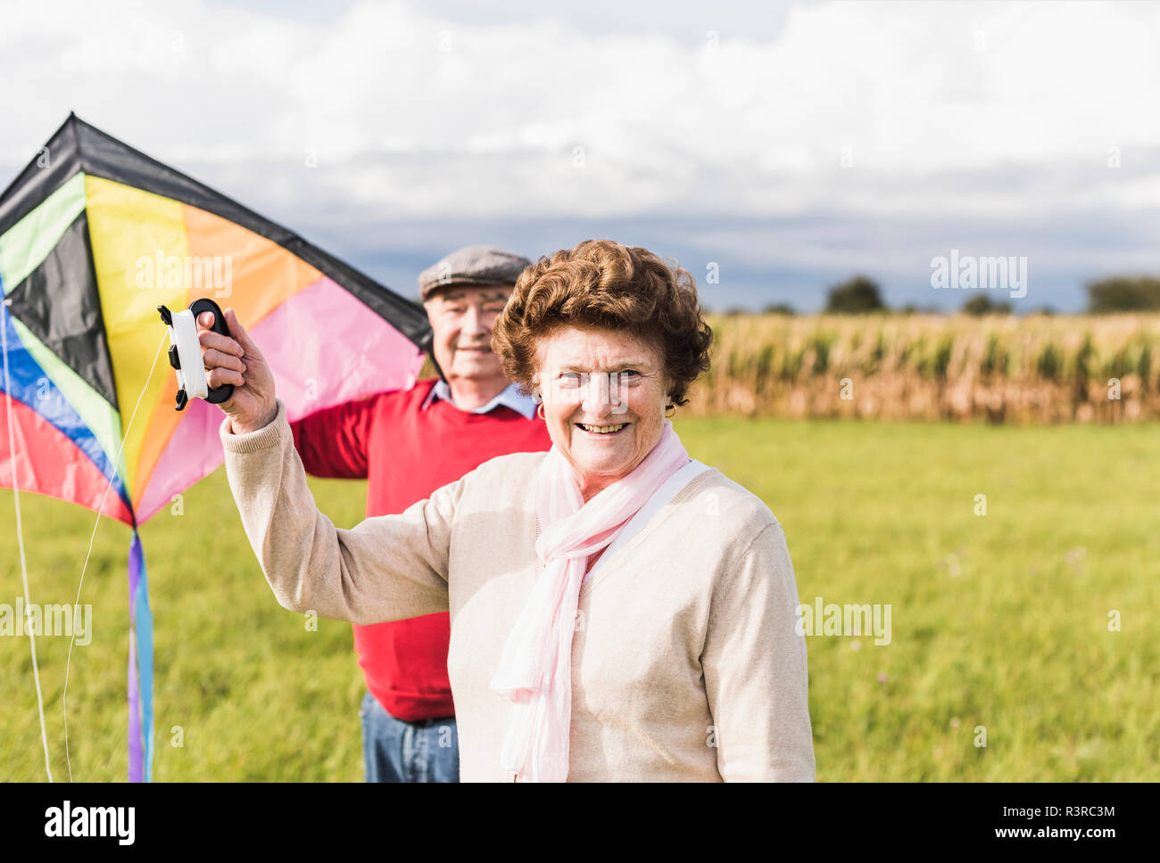 Portrait von lächelnden senior Paar mit Kite in ländlichen Landschaft Stockfoto