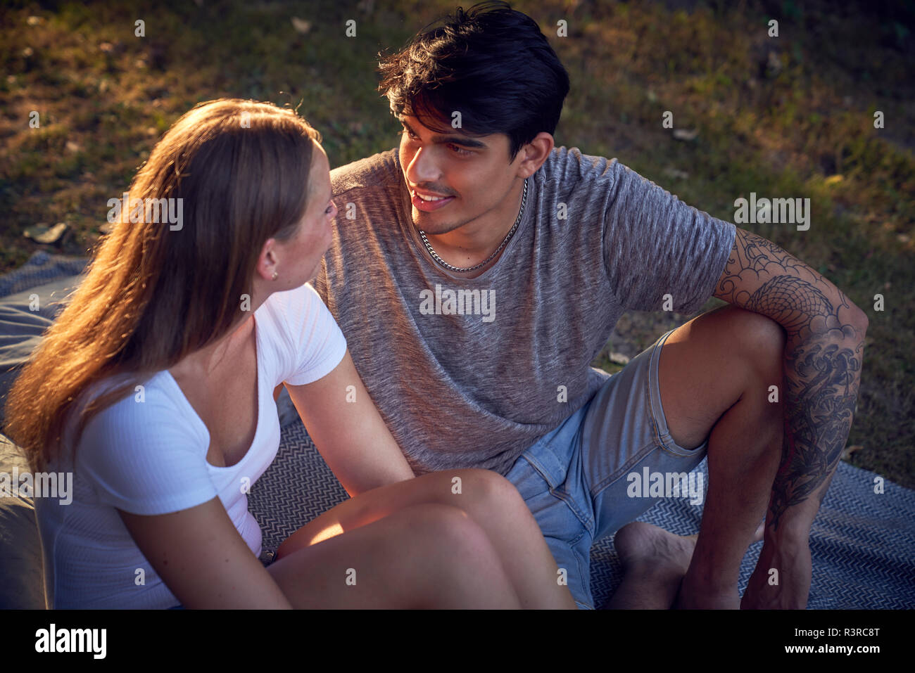 Romantische junge Paar im Park sitzen, den Sonnenuntergang genießen. Stockfoto