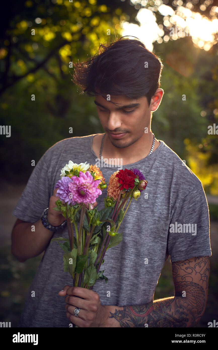 Junger Mann wartet mit ein paar Blumen Stockfoto