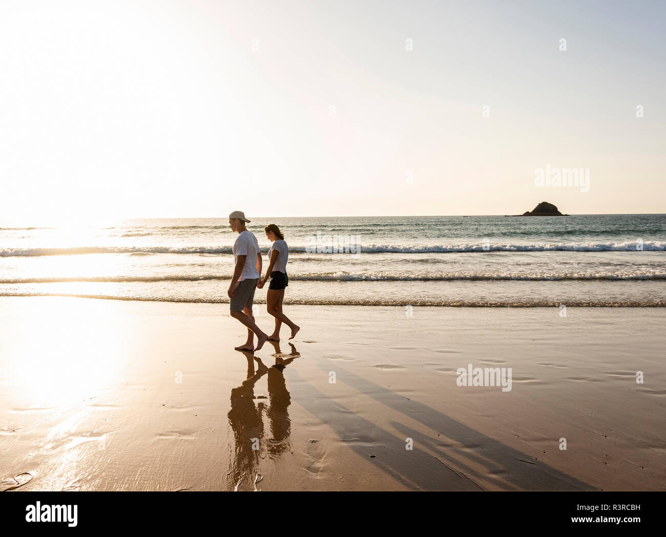 Junges Paar einen romantischen Strand Spaziergang bei Sonnenuntergang Stockfoto