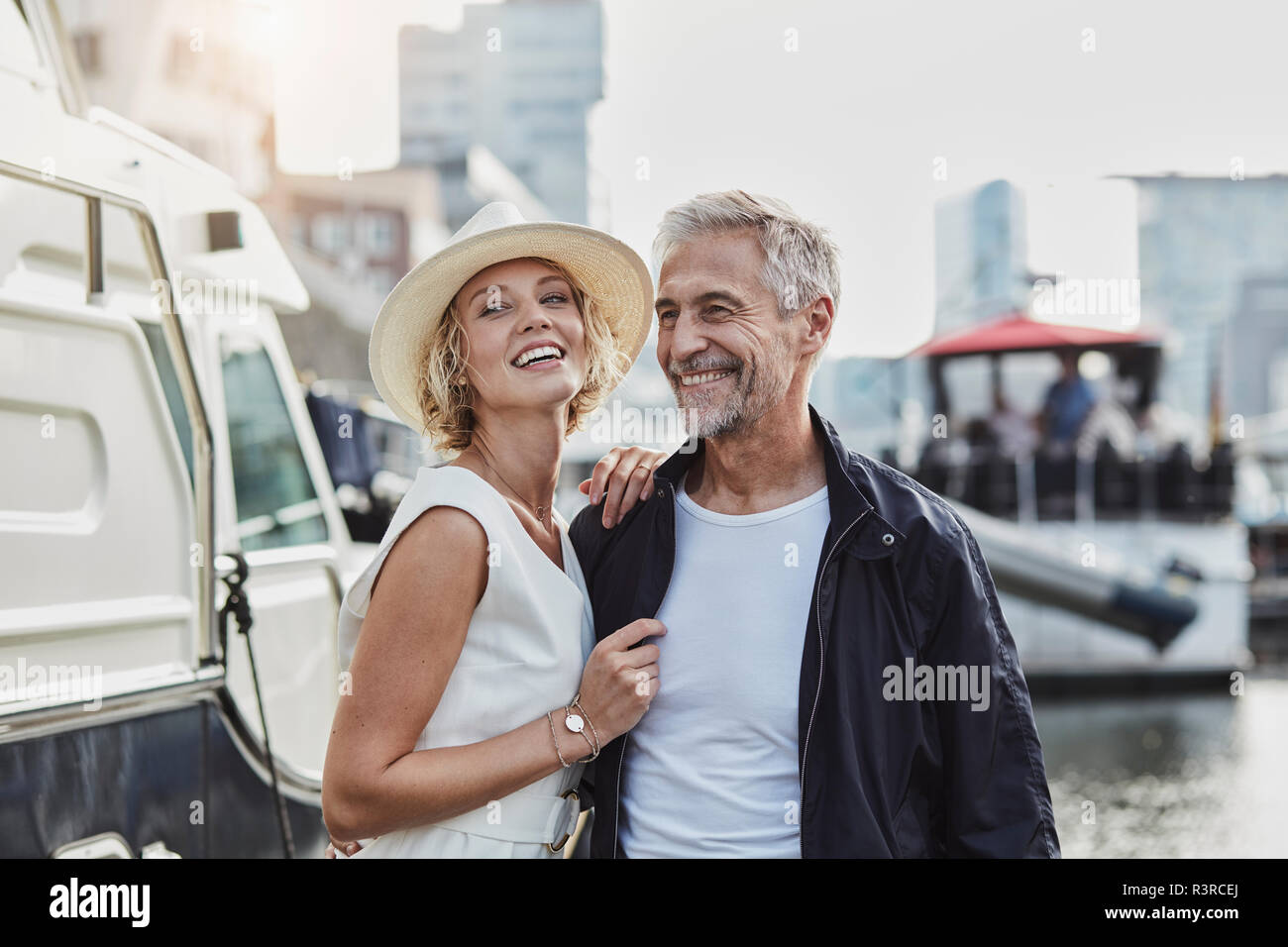 Ältere Menschen und junge Frau an einem Jachthafen neben dem Yacht Stockfoto