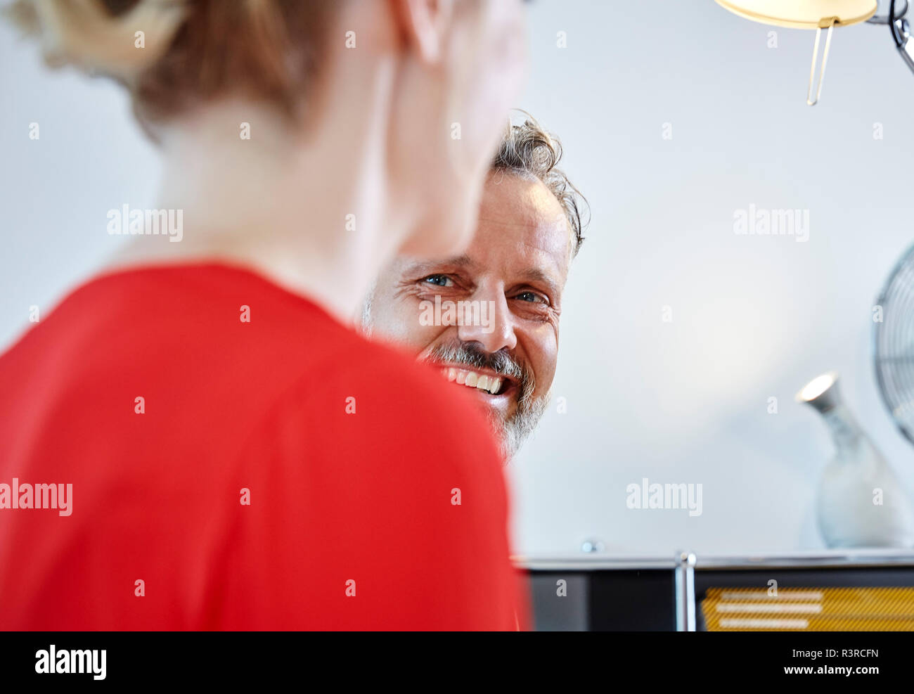Lächelnd reifer Mann bei weiblichen Kollegen suchen Stockfoto