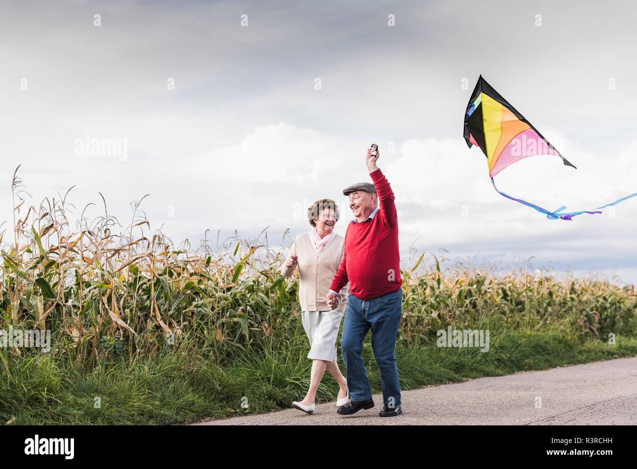 Gerne älteres Paar mit Kite in ländlichen Landschaft Stockfoto
