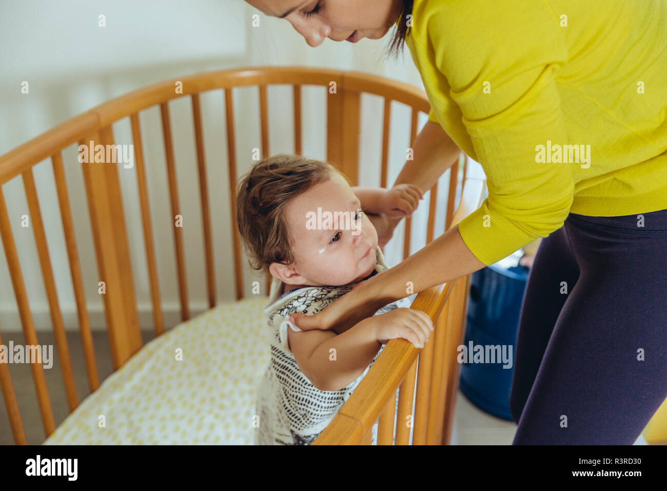 Mutter sie ihr Baby Mädchen vom Bett Stockfoto