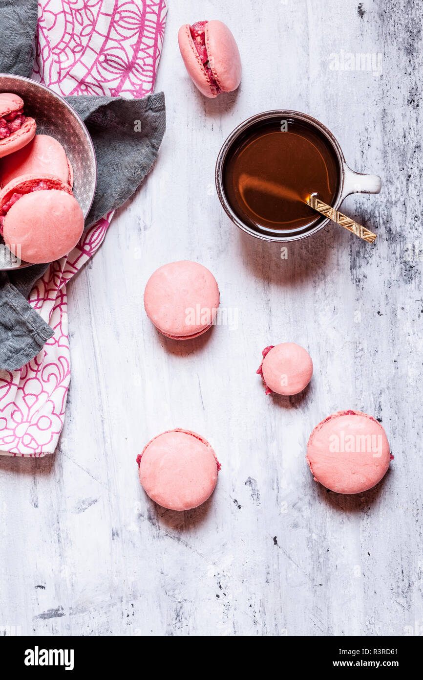 Rosa macarons gefüllt mit Himbeere buttercream und einer Tasse Kaffee Stockfoto