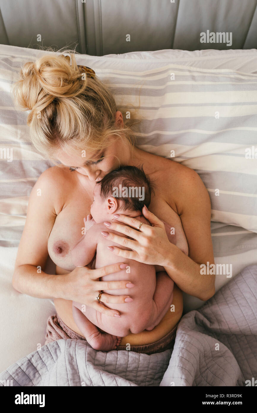 Neugeborenes liegend Haut an Haut mit Mutter im Bett Stockfoto