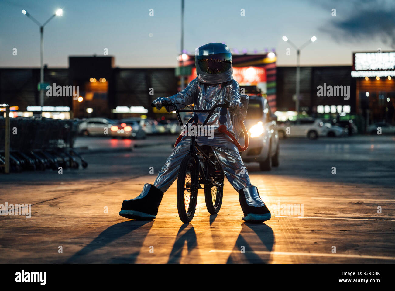 Spaceman in der Stadt in der Nacht auf Parkplatz mit BMX Bike Stockfoto