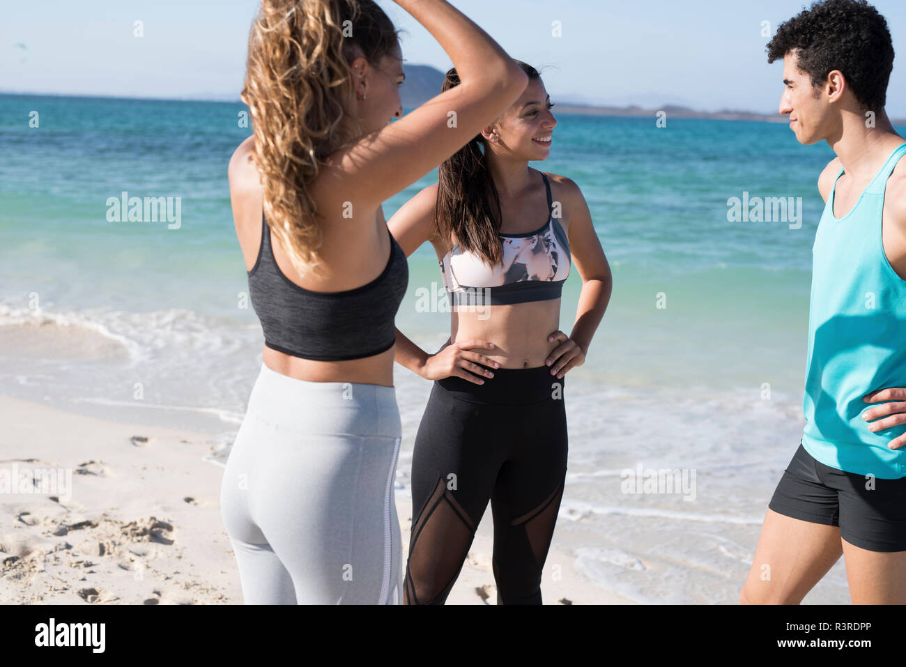 Spanien, Kanarische Inseln, Fuerteventura, drei junge Athleten der Unterhaltung am Strand Stockfoto