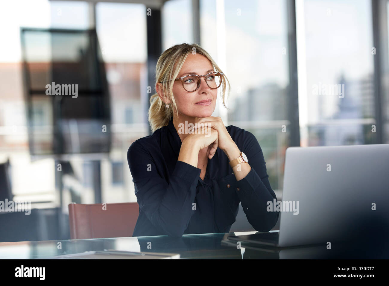 Geschäftsfrau am Schreibtisch sitzen und denken Stockfoto