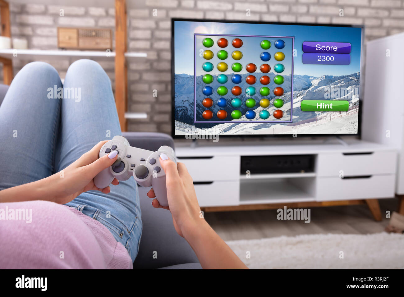 Frau mit Joystick beim Spielen von Spiel zu Hause im Fernsehen Stockfoto