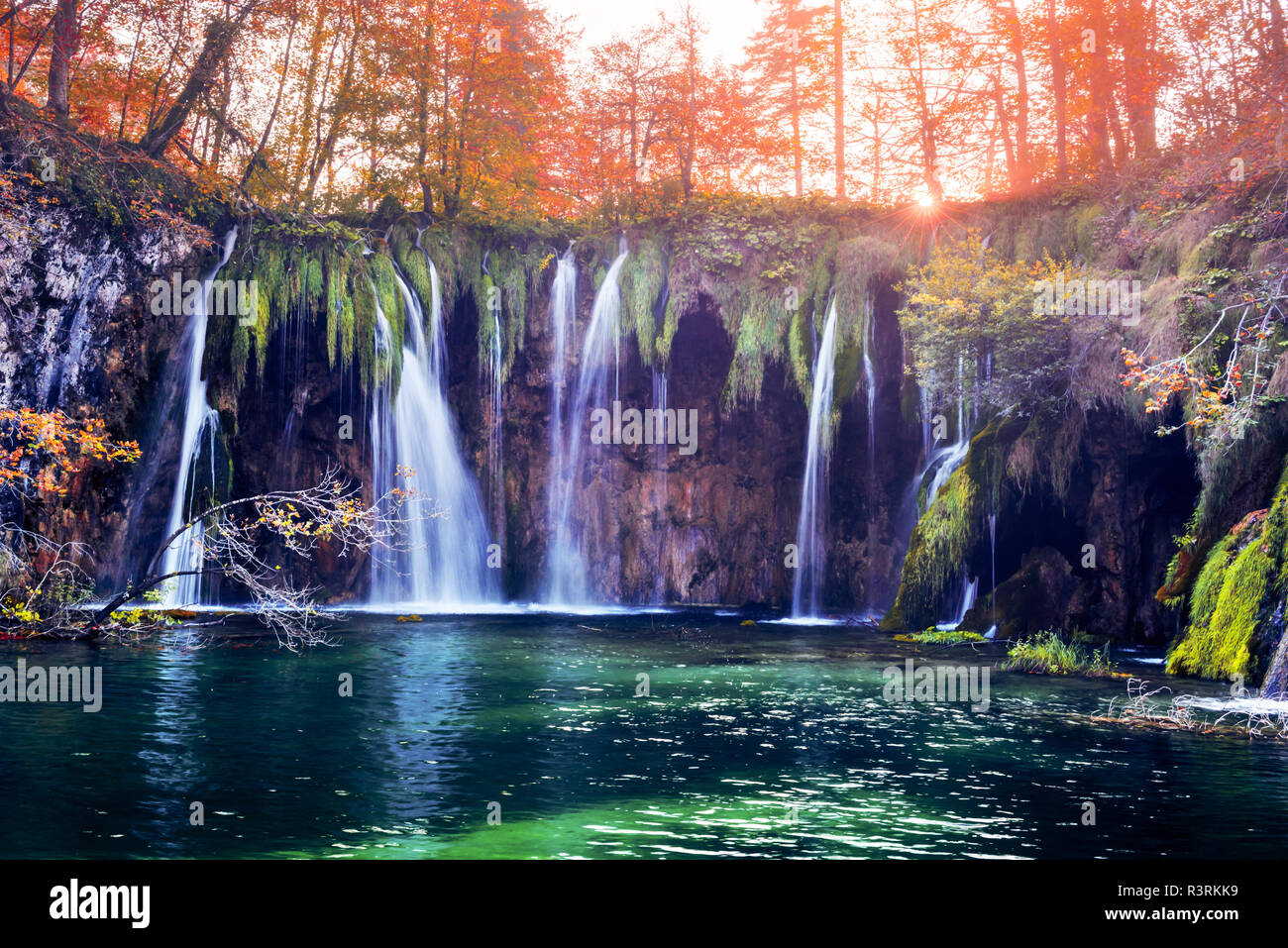 Erstaunliche Wasserfall mit reinen blauen Wasser der Plitvicer Seen. Orange Herbst Wald für den Hintergrund. Nationalpark Plitvice, Kroatien. Landschaftsfotografie Stockfoto