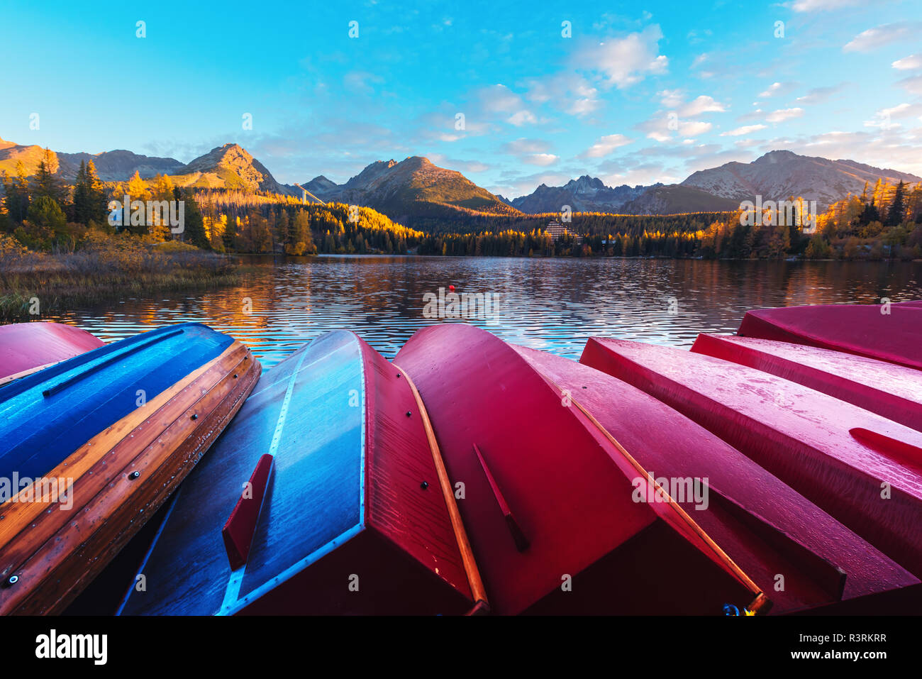 Malerischer herbst Blick auf den See Strbske Pleso in der hohen Tatra, Slowakei. Reihe der rote hölzerne Boote und die hohen Berge im Hintergrund. Stockfoto
