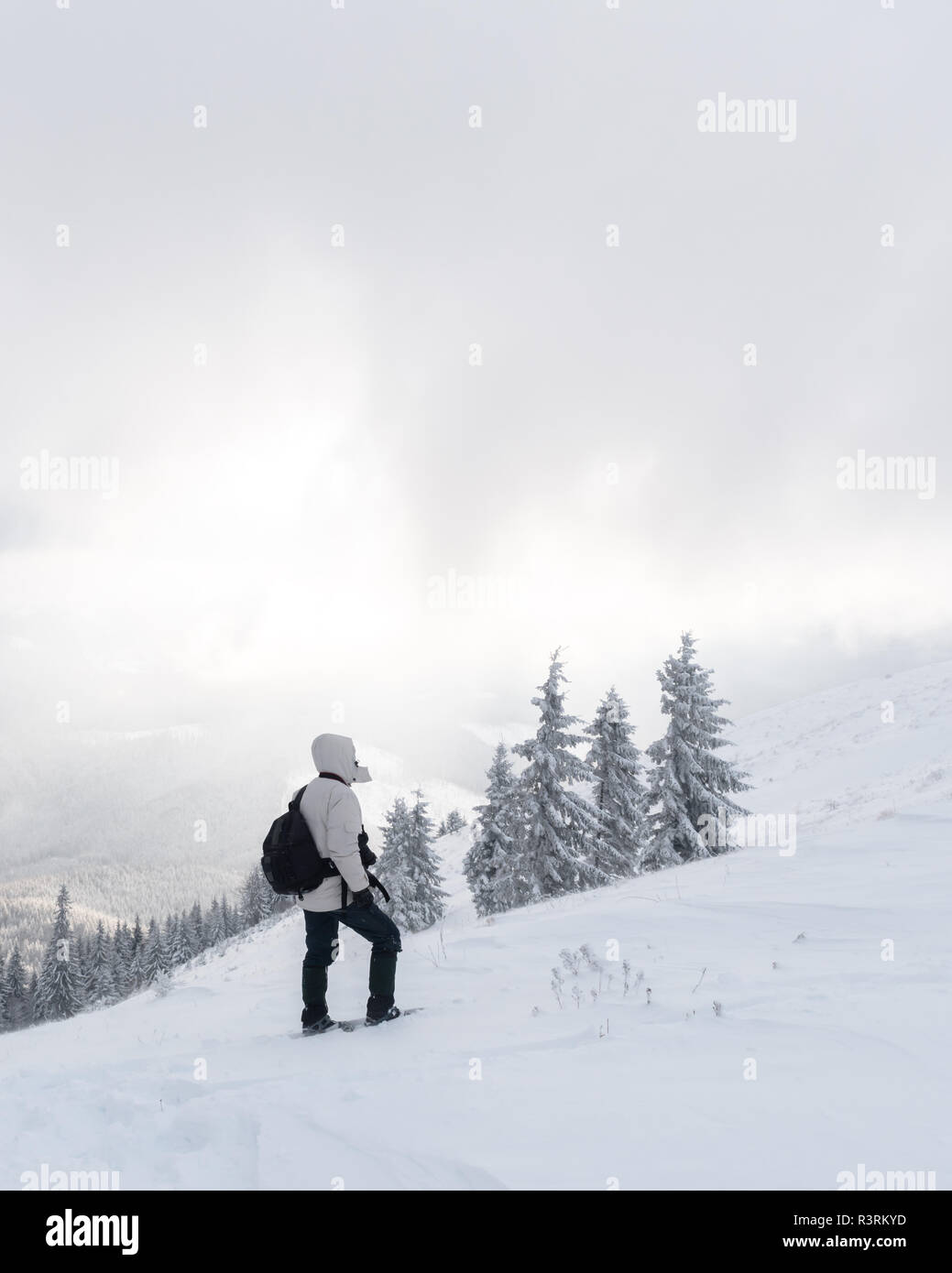 Allein die Touristen mit einem Rucksack in die hohen Berge im Winter. Travel Concept Stockfoto