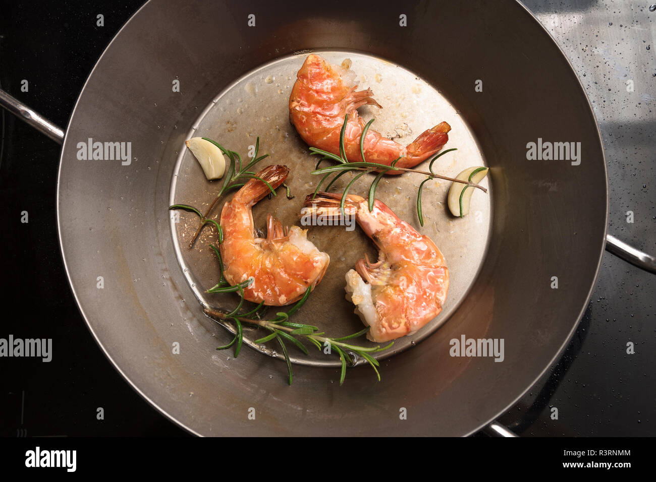 Gebratene Garnelen mit Rosmarin und Knoblauch in einer Pfanne, Essen und cokking Konzept, hohe Winkel, Ansicht von oben mit Kopie Raum, ausgewählte konzentrieren Stockfoto