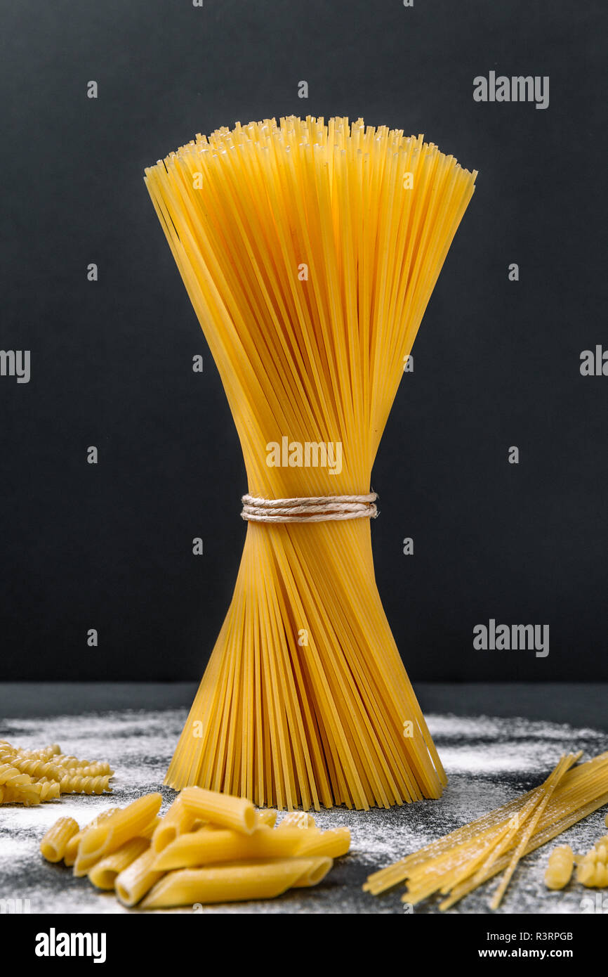 Spaghetti in Bündel auf schwarzem Hintergrund Stockfoto