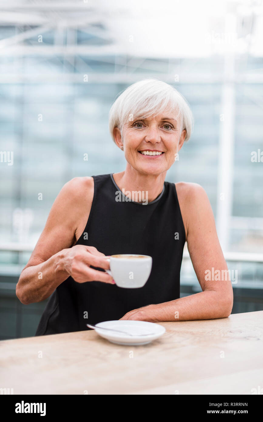 Portrait von lächelnden älteren Frau trinkt einen Kaffee Stockfoto