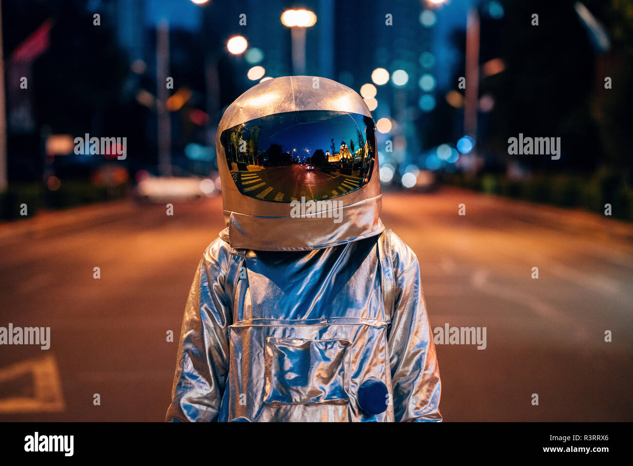 Spaceman auf einer Straße in der Stadt bei Nacht Stockfoto