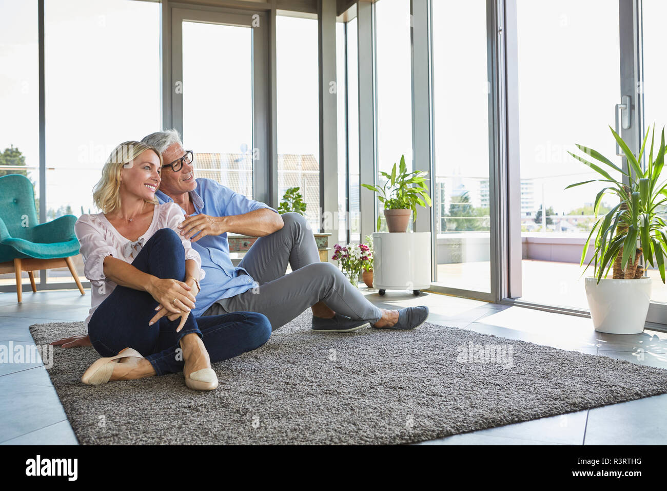 Lächelnd reifes Paar entspannt zu Hause Blick aus Fenster Stockfoto