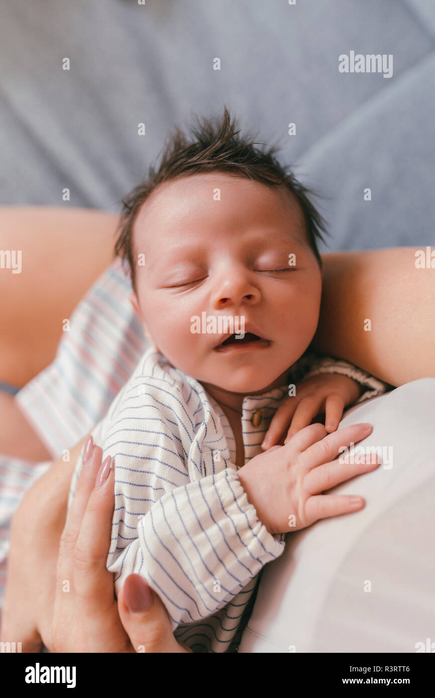 Portrait von Neugeborenen mit geschlossenen Augen von Mutter gehalten wird Stockfoto