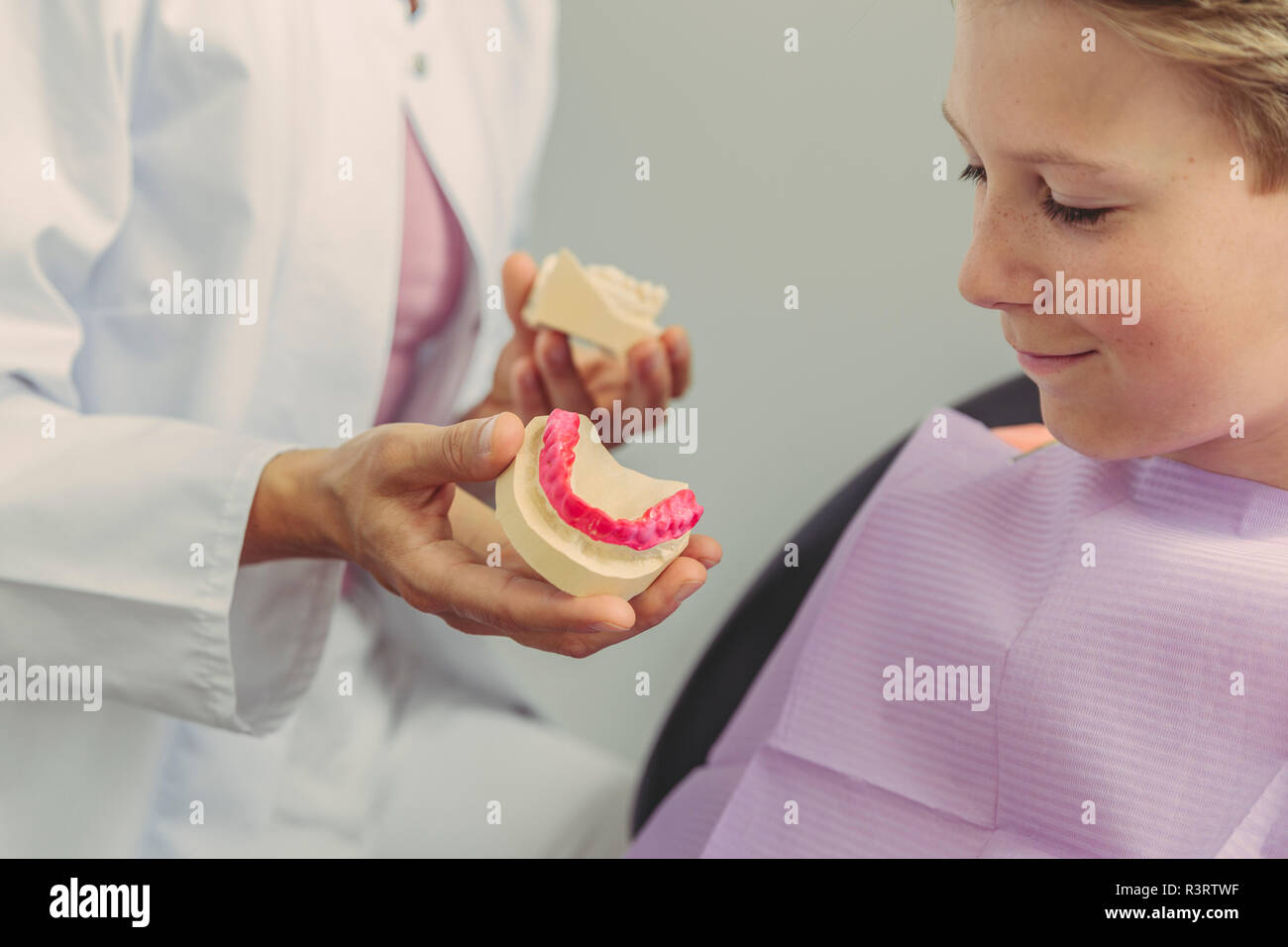 Weiblichen Zahnarzt erklären Junge ein Zahn Modell Stockfoto