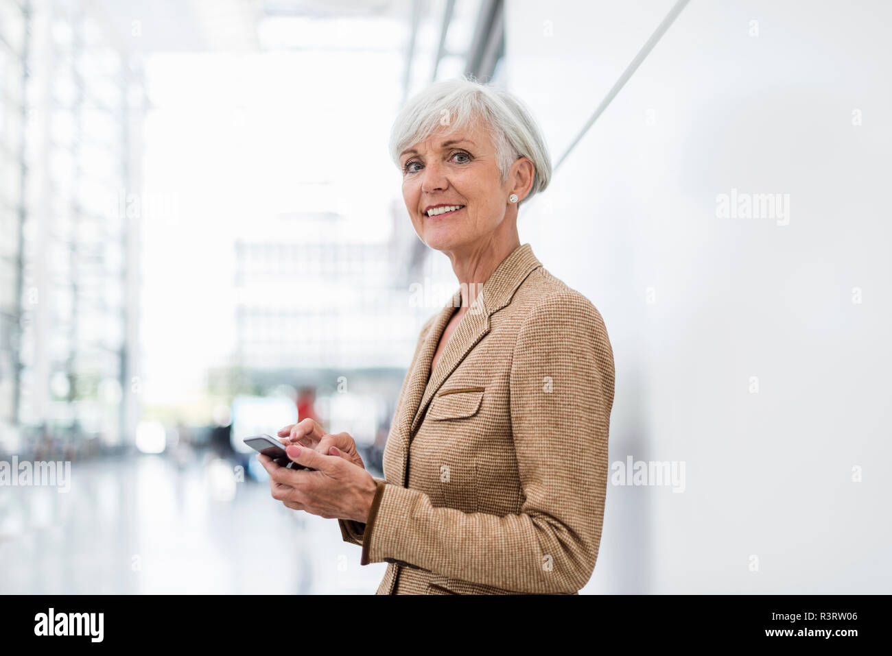 Portrait von lächelnden senior Geschäftsfrau mit Handy Stockfoto