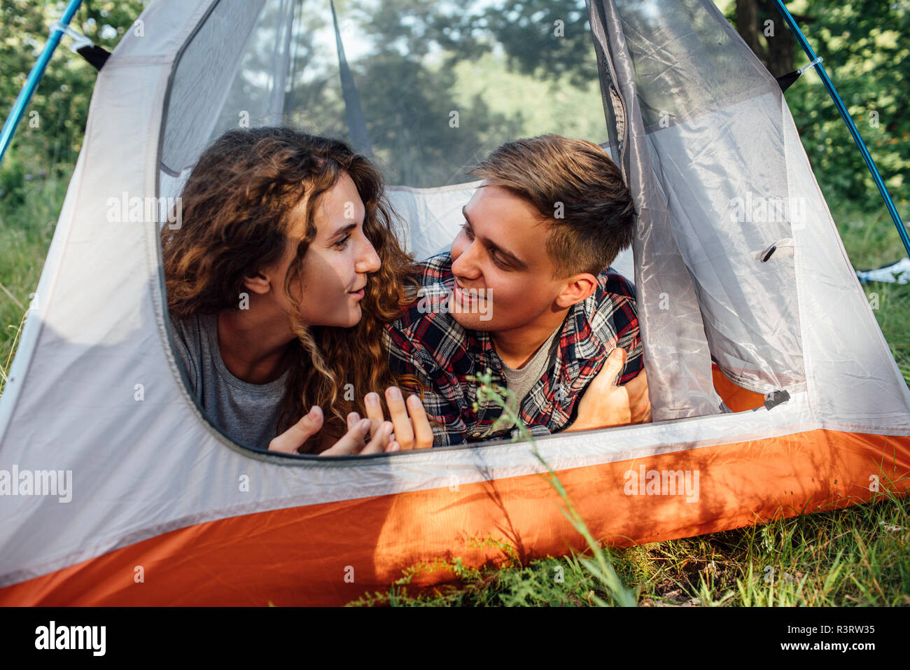 Glückliches junges Paar im Zelt liegen, sprechen Stockfoto