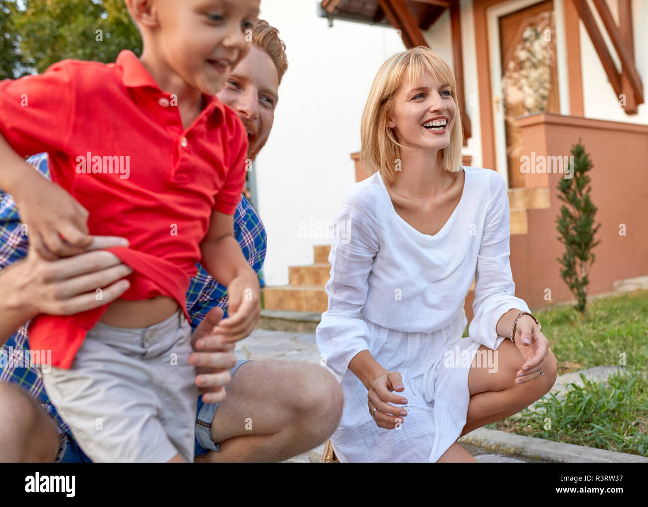 Happy Family im Garten ihres Hauses Stockfoto