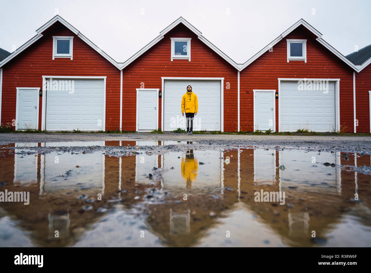 Norwegen, Mann, der vor der Reihe der Hütten Stockfoto