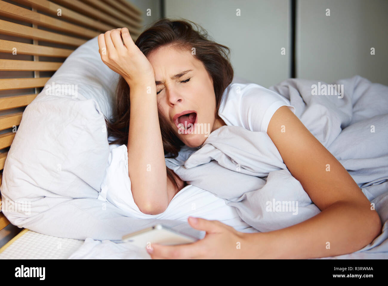 Portrait von gähnen Frau im Bett lag, Stockfoto