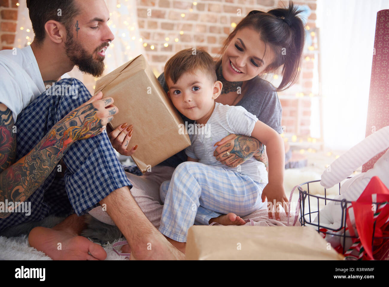 Junge empfangen von Weihnachten von seinen Eltern im Bett vorhanden Stockfoto