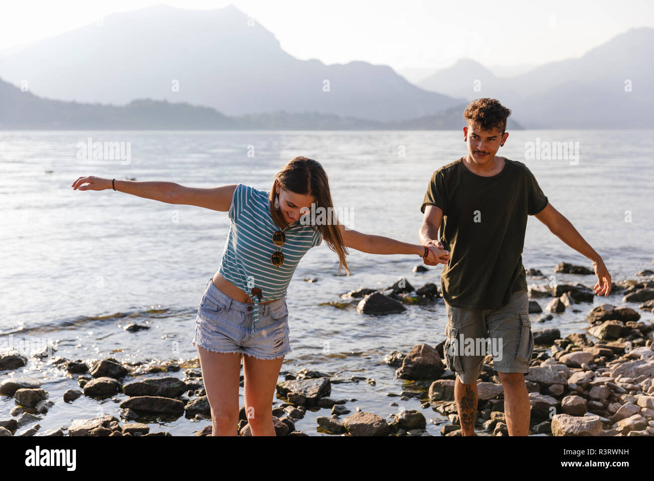 Junges Paar Hand in Hand am See Stockfoto