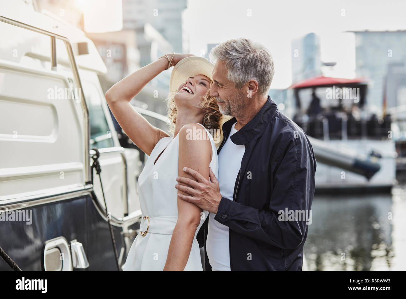 Ältere Menschen und junge Frau an einem Jachthafen neben dem Yacht Stockfoto