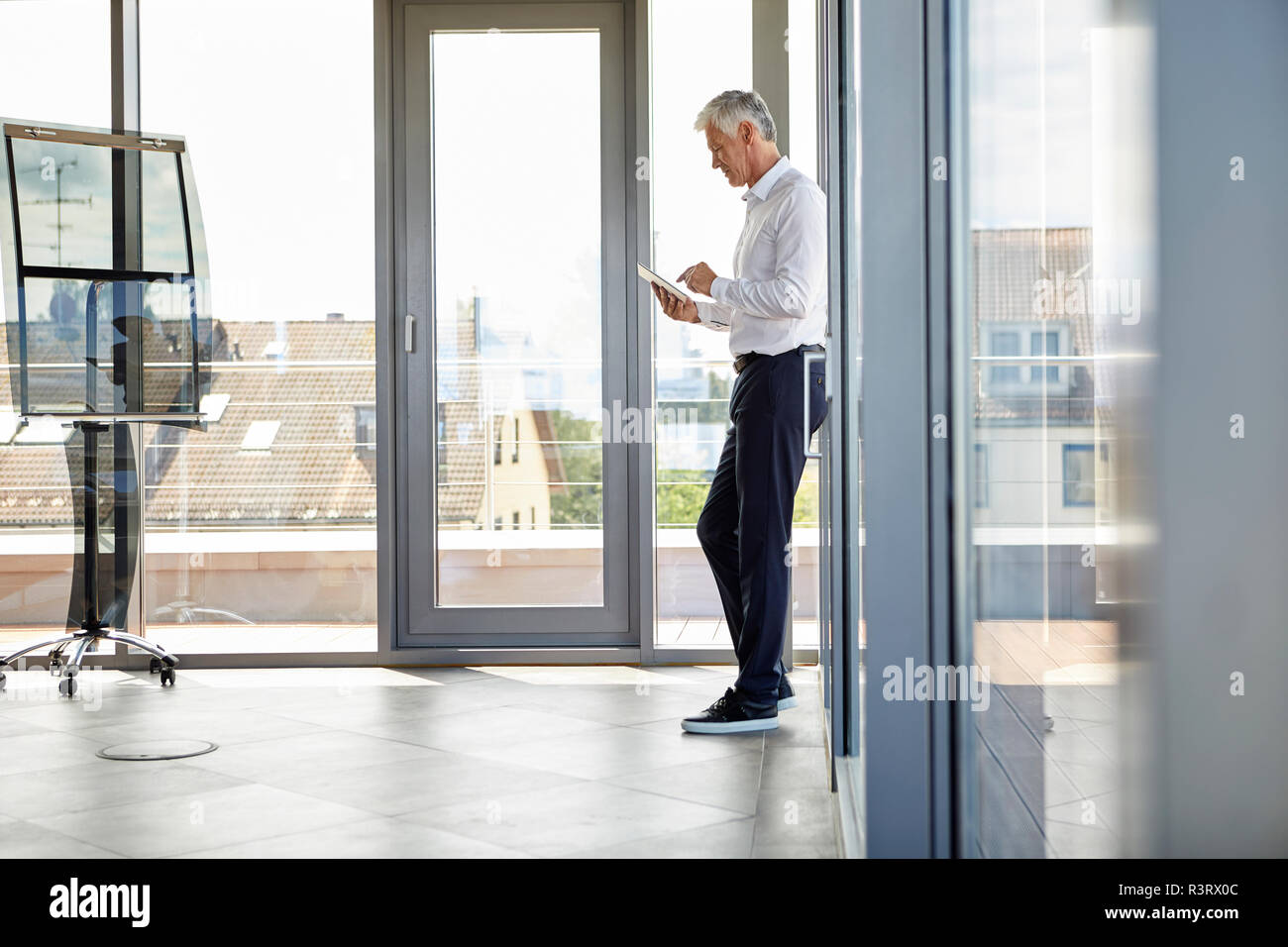 Erfolgreicher Geschäftsmann in Büro, mit digitalen Tablet Stockfoto