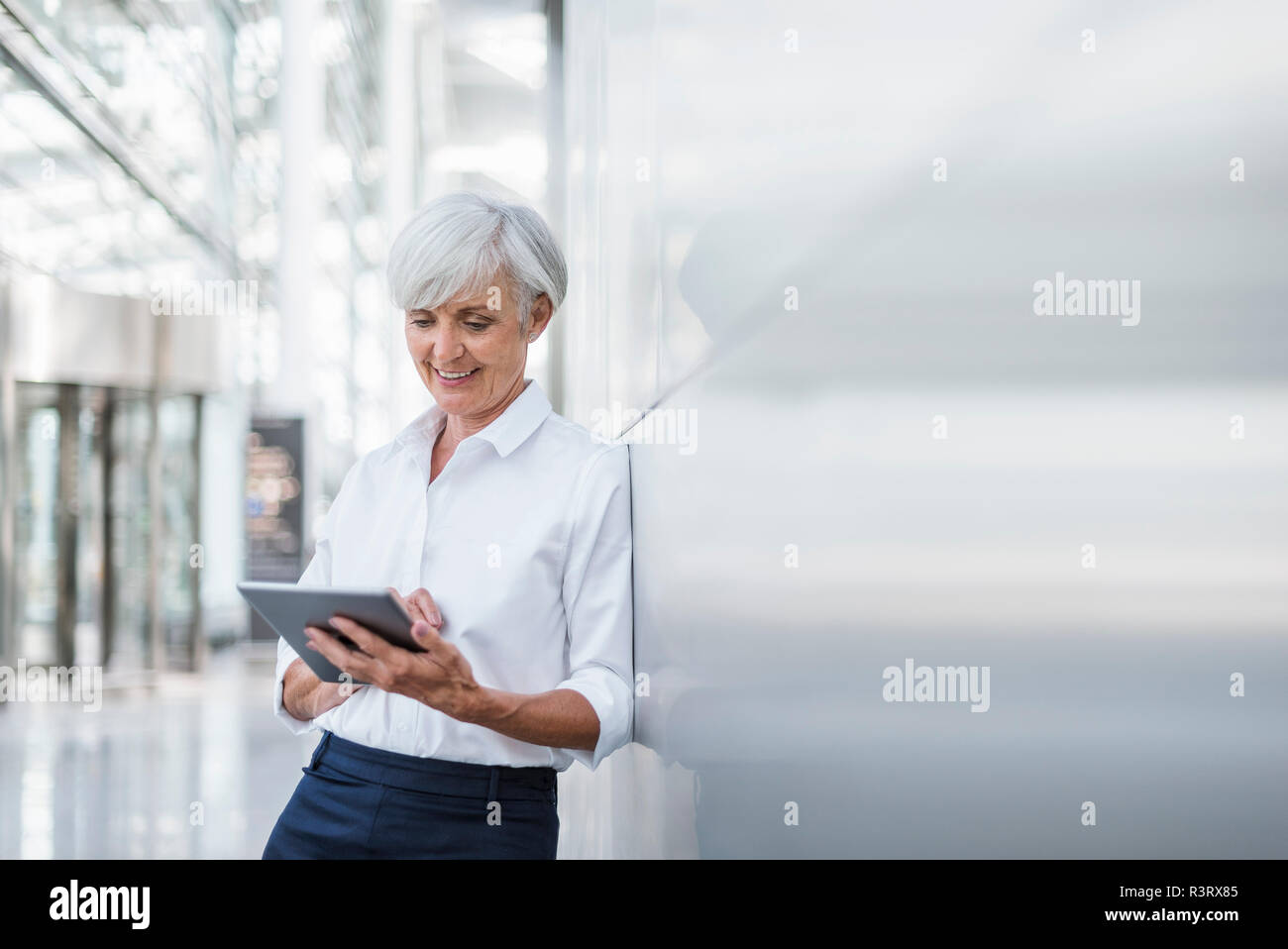 Lächelnd senior Geschäftsfrau mit Tablet Stockfoto