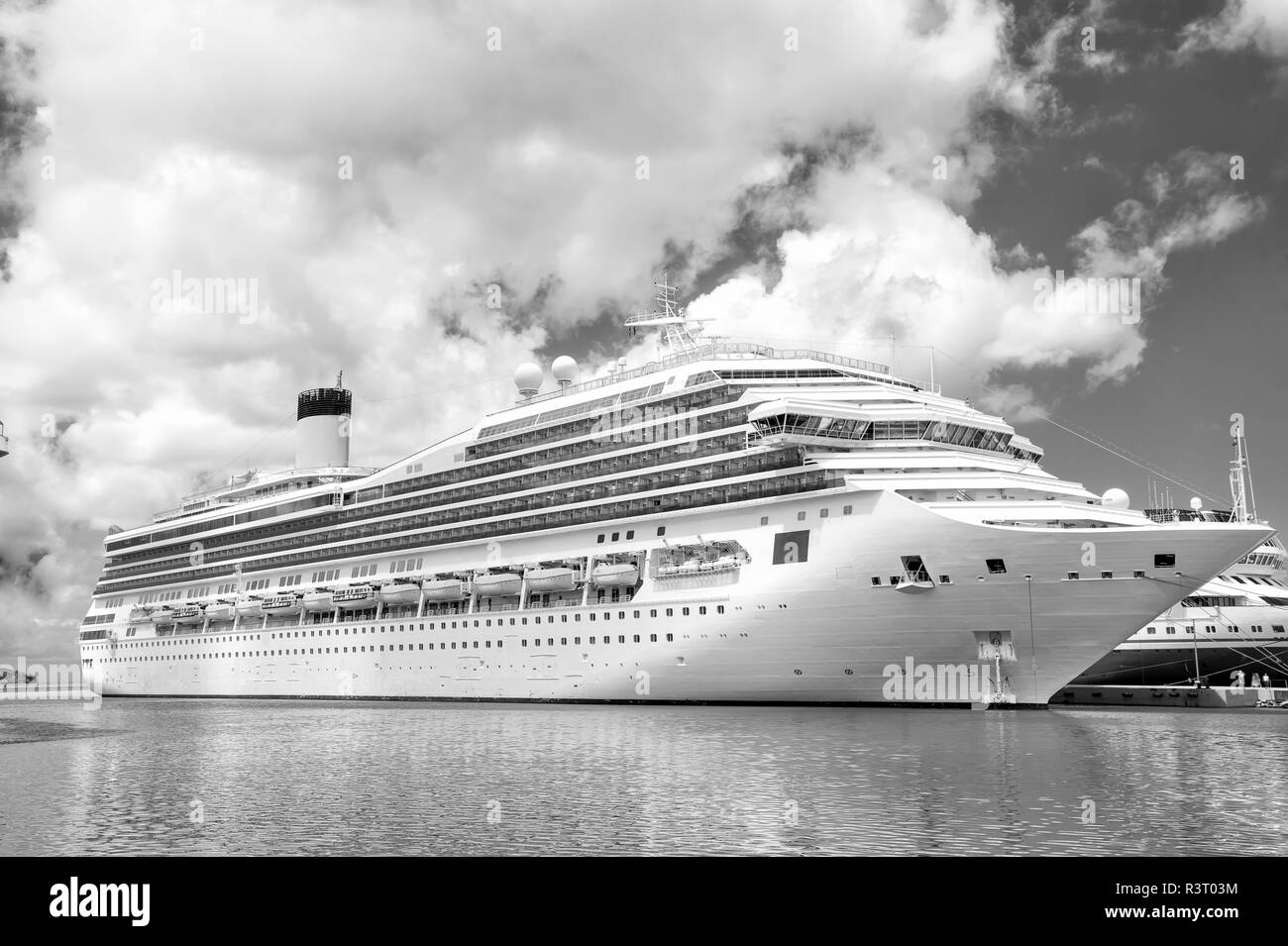 Große luxuriöse Kreuzfahrtschiff oder Buchse am Meer Wasser und bewölkter Himmel Hintergrund angedockt am Hafen von St. Johns, Antigua Stockfoto