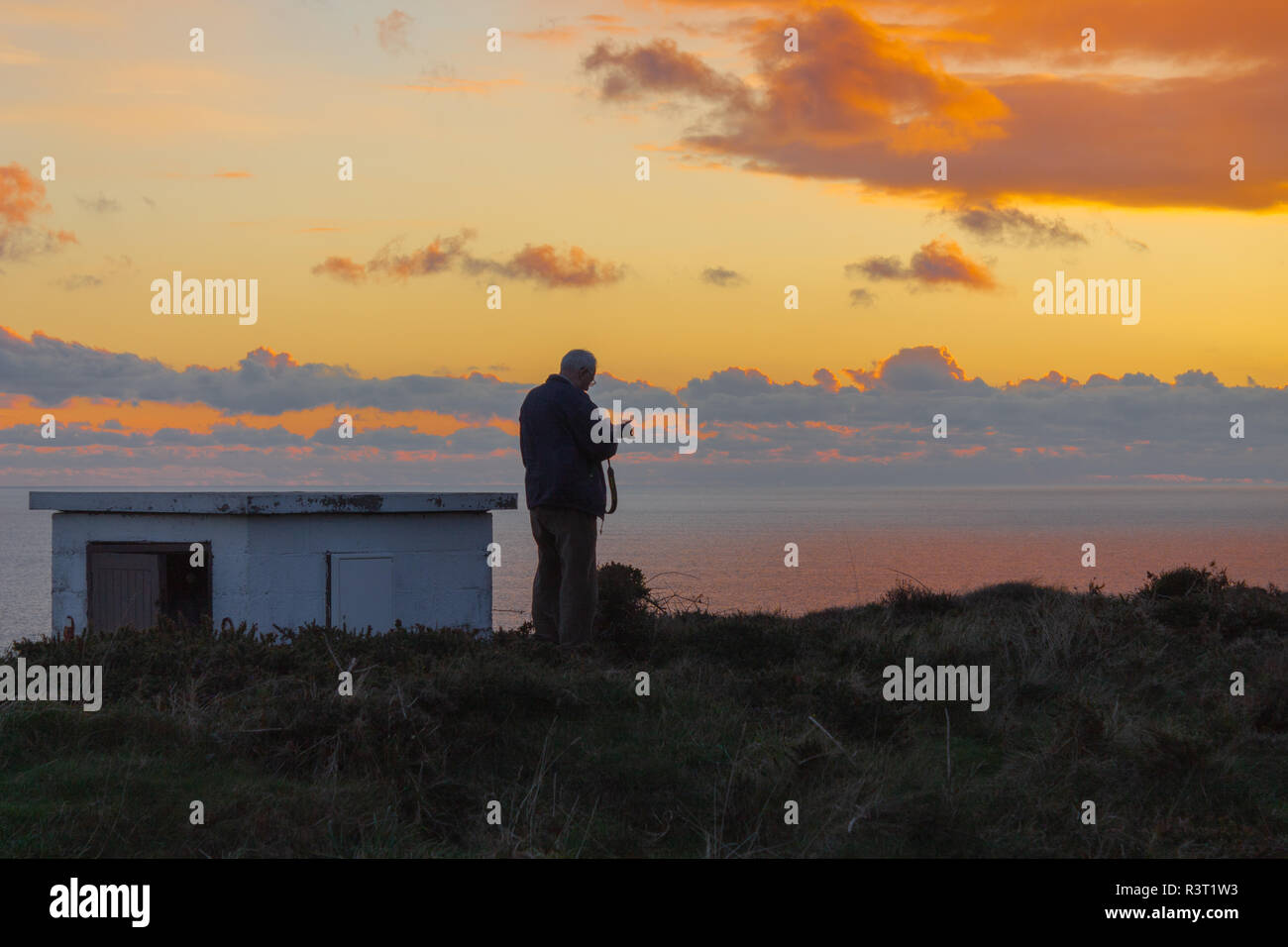 Fotograf sucht sein Bild nach der Aufnahme eines Bildes auf den Sonnenuntergang oder Sonnenuntergang. Stockfoto