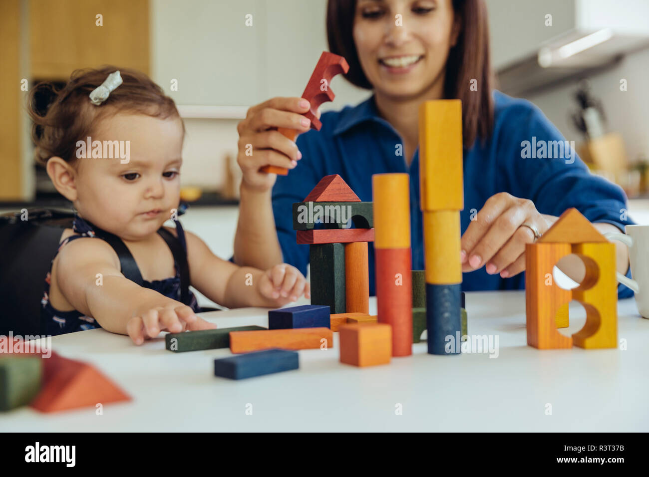 Glückliche Mutter und Tochter spielen mit Bausteine Stockfoto