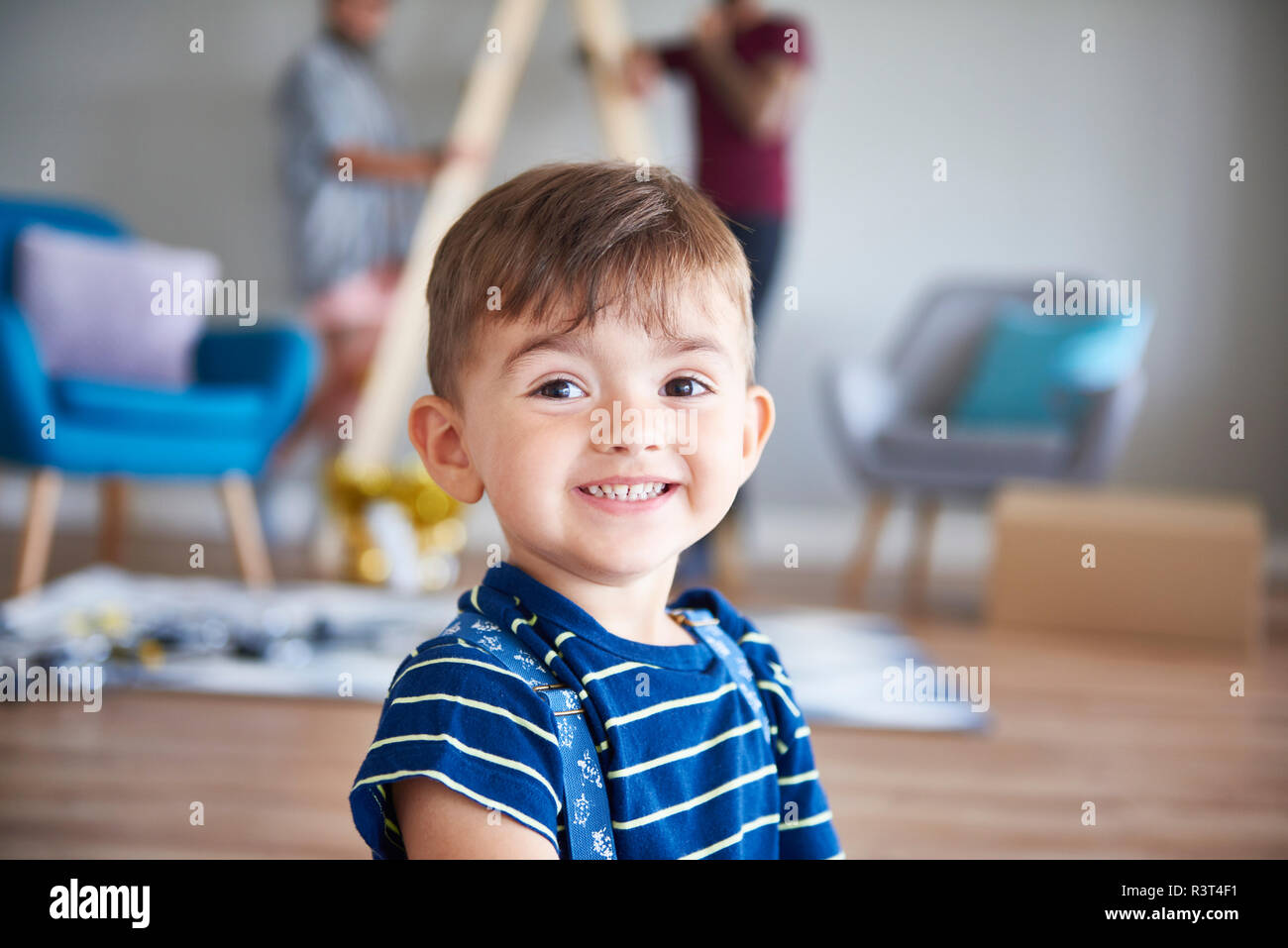 Portrait von lächelnden Jungen zu Hause mit Eltern im Hintergrund Stockfoto
