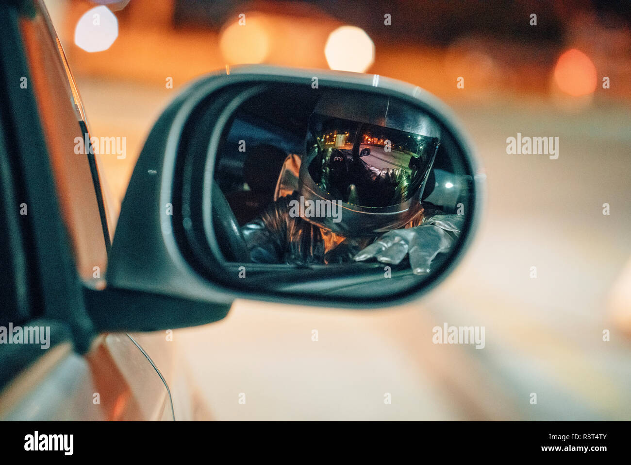 Reflexion von spaceman im Rückspiegel eines Autos in der Nacht Stockfoto