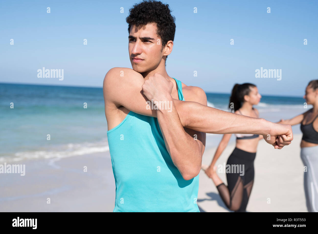Spanien, Kanarische Inseln, Fuerteventura, junger Mann streckte seine Arm am Strand Stockfoto