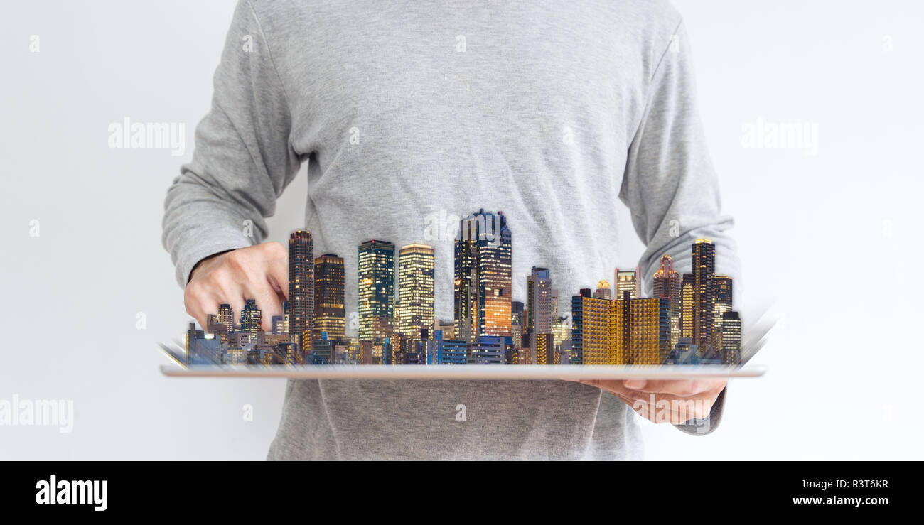 Ein Mann mit digitalen Tablet mit modernen Gebäuden Hologramm. Immobilien Unternehmen und Investitionen, Gebäudetechnik Stockfoto