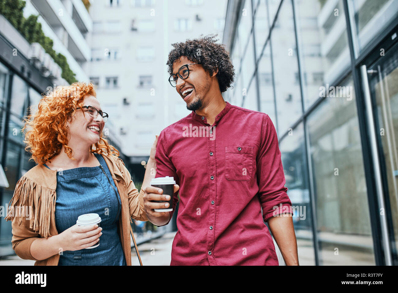 Kollegen gemeinsam zu Fuß in der Stadt, Frau trinkt Kaffee Stockfoto