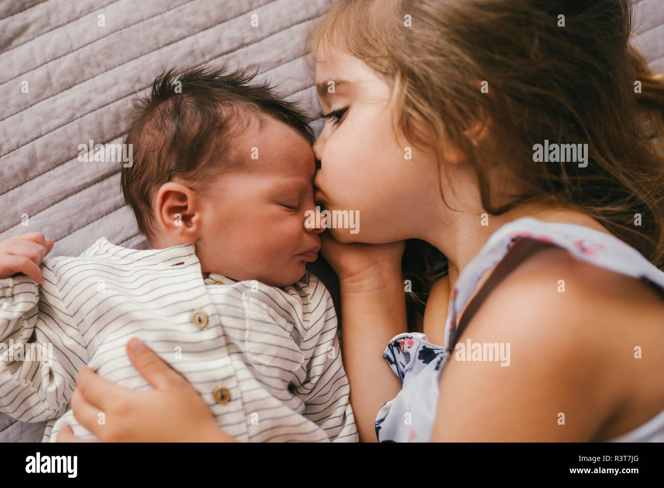 Liebevolle Mädchen liegt auf Decke Kuscheln mit Ihrem Baby Bruder Stockfoto