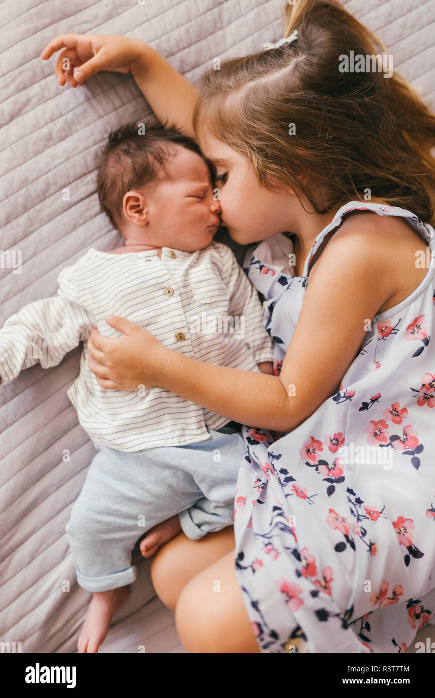 Liebevolle Mädchen liegt auf Decke Kuscheln mit Ihrem Baby Bruder Stockfoto