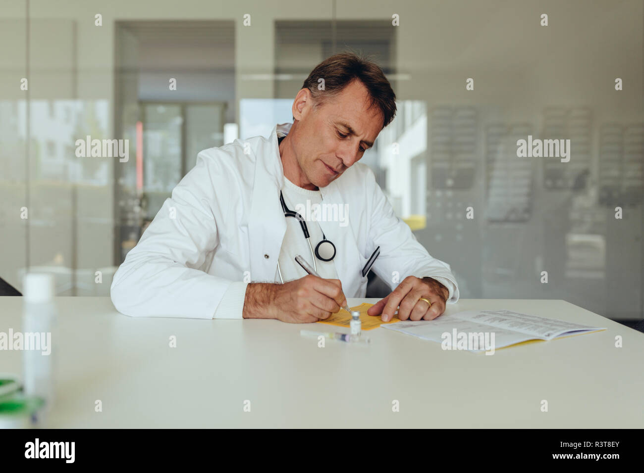 Arzt sitzen in der Praxis, Abfüllung in Immunisierung Karte Stockfoto