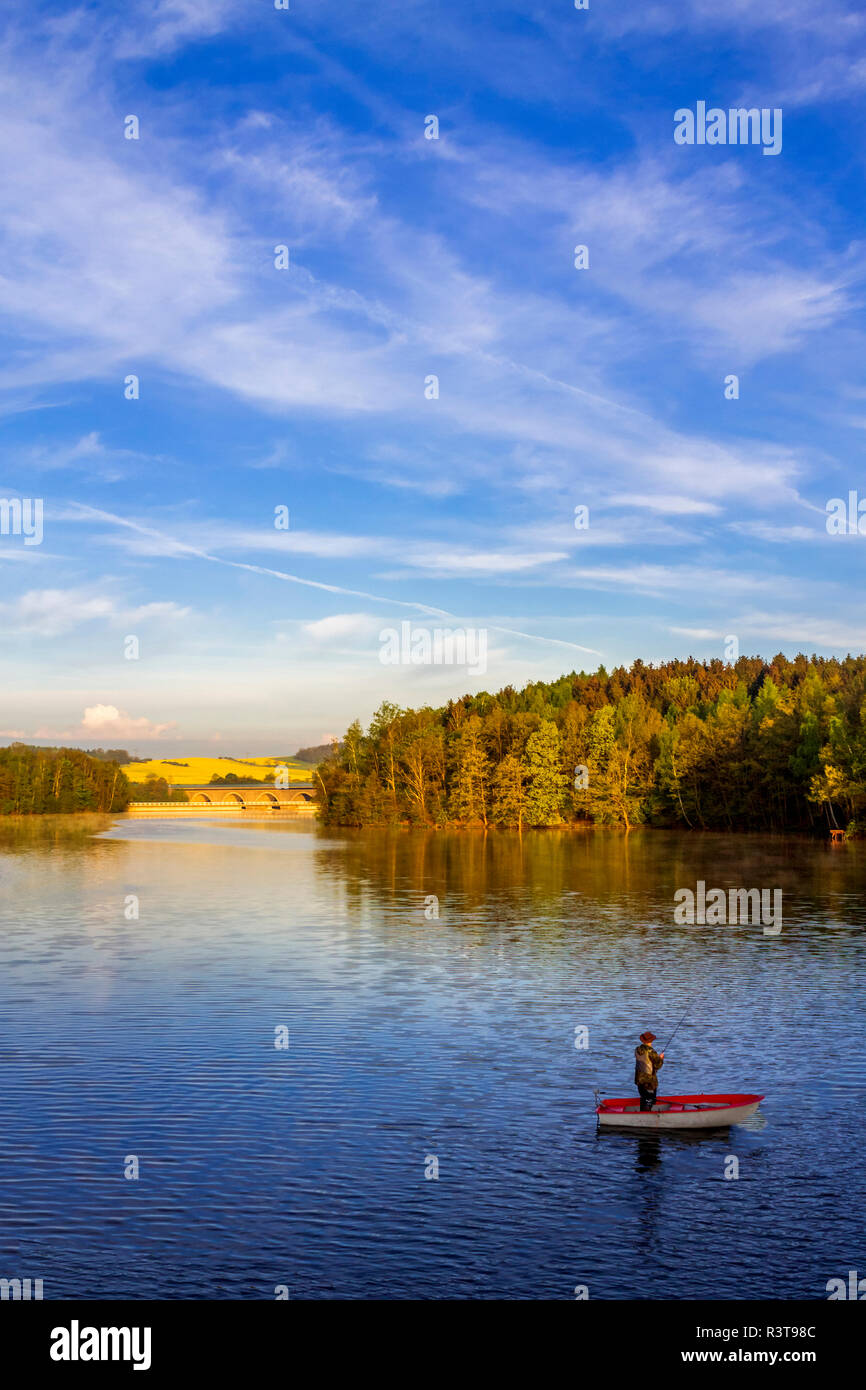 Deutschland, Mann in einem Boot angeln auf einem Damm Stockfoto