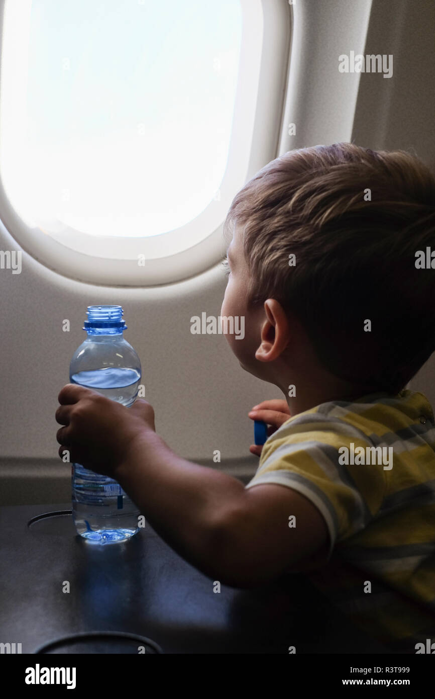 Kleiner Junge in einem Flugzeug Blick aus Fenster Stockfoto