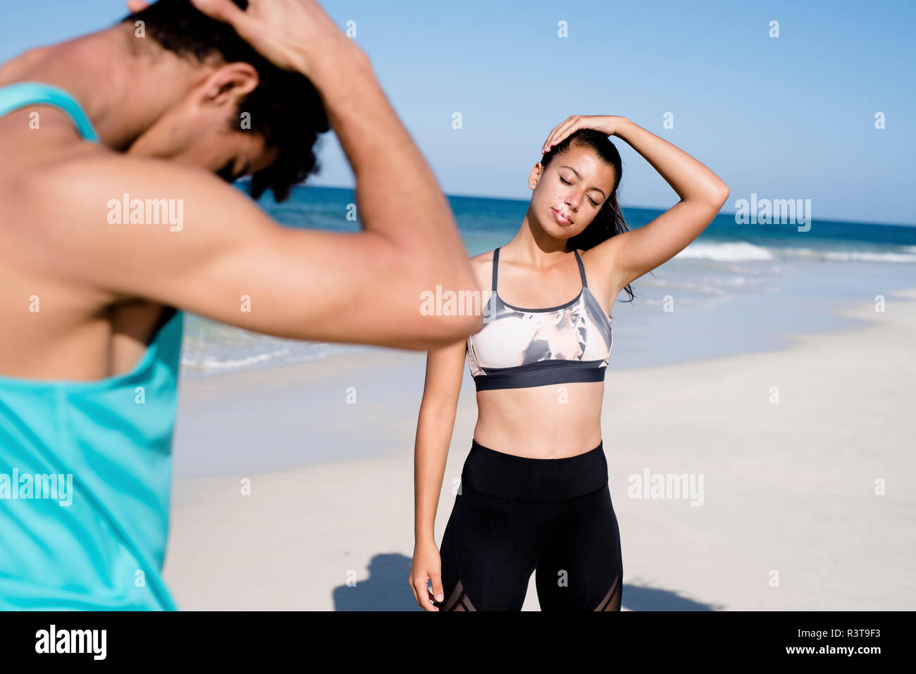 Spanien, Kanarische Inseln, Fuerteventura, junge womand und ein junger Mann am Strand trainieren Stockfoto